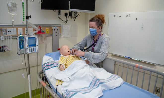 A nurse training with a Sim Doll.