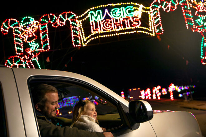 Father and daughter looking out the car window at Christmas lights